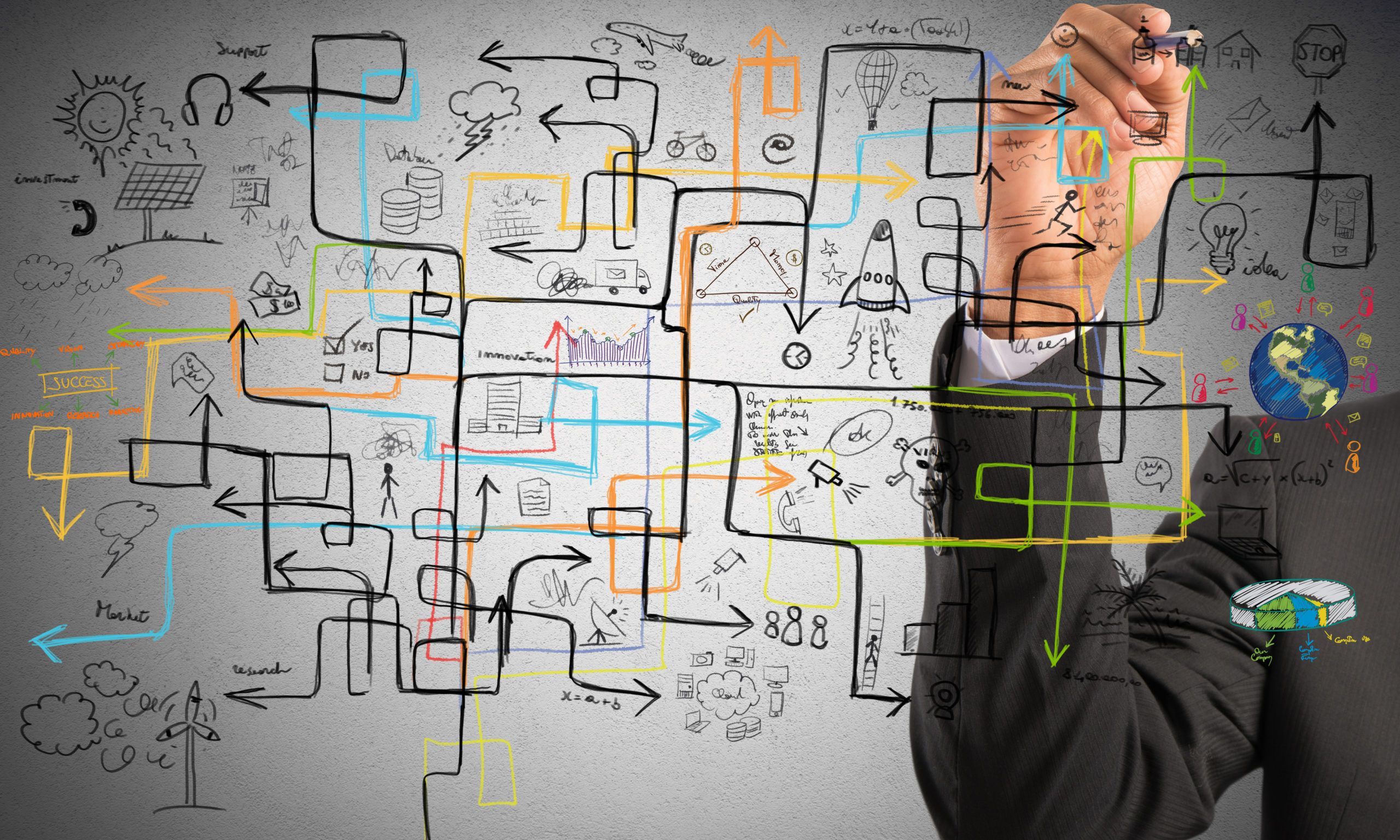 Businessman in a suit sketches a complex, colorful flowchart of interconnected ideas, icons, and arrows on a wall.